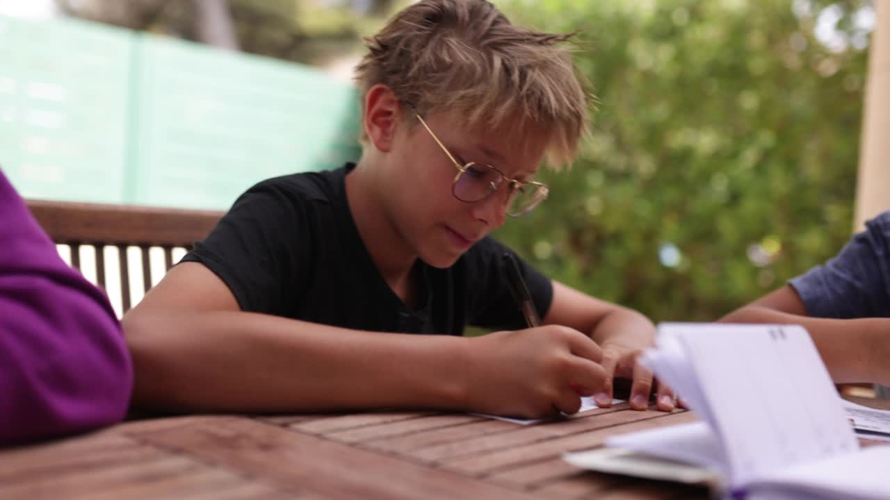 青少年坐在后院的桌子旁写明信片视频下载