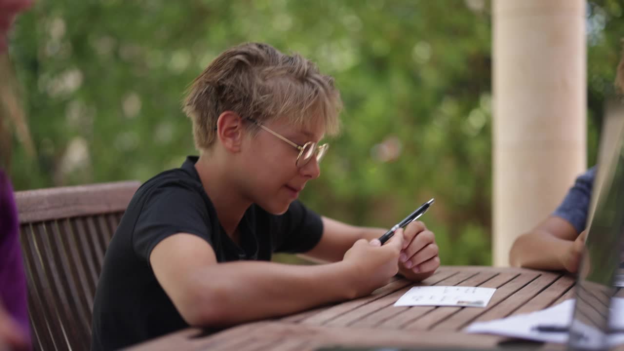青少年坐在后院的桌子旁写明信片视频下载