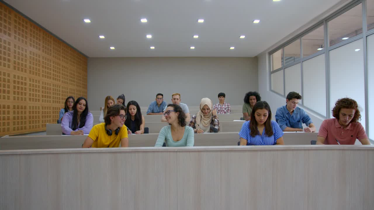 一群大学生在课堂上举手向老师提问视频素材