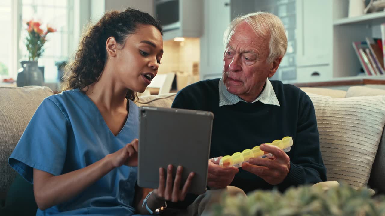 一名女护士用数码平板电脑给她的老病人看药盒的4k视频视频下载