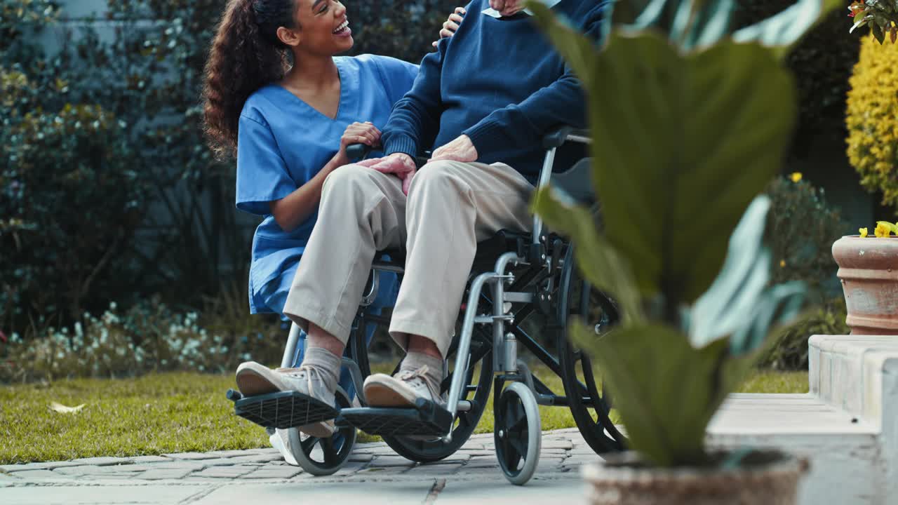 一个女护士坐在外面和一个坐轮椅的老年病人坐在一起的4k视频视频素材