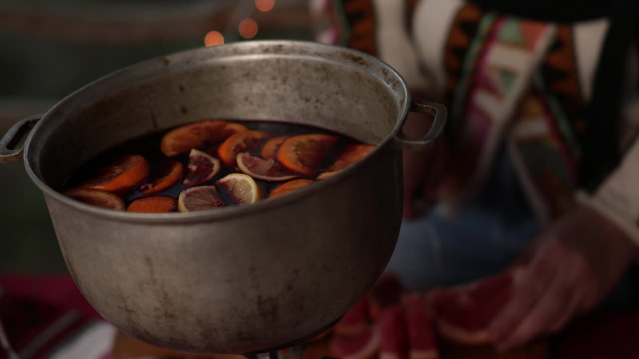 双手将葡萄柚片放入盛有传统圣诞热酒的大锅中视频素材
