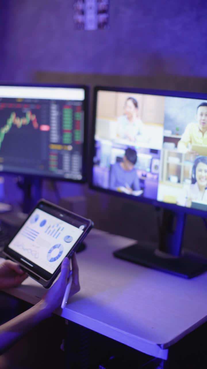 亚洲女商人使用电脑投资股票市场，同时学习从电话会议工作到深夜在公寓视频下载