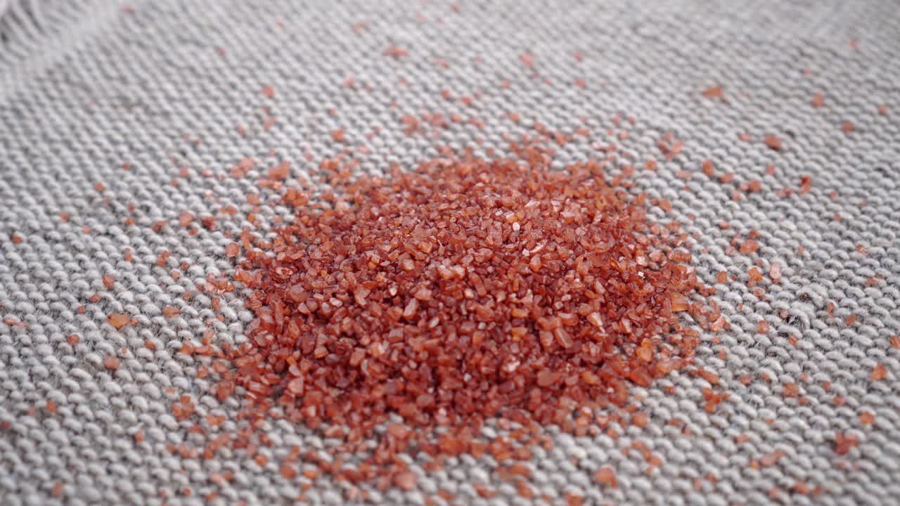 红色夏威夷海盐晶体在粗糙粗糙的黄麻表面视频素材