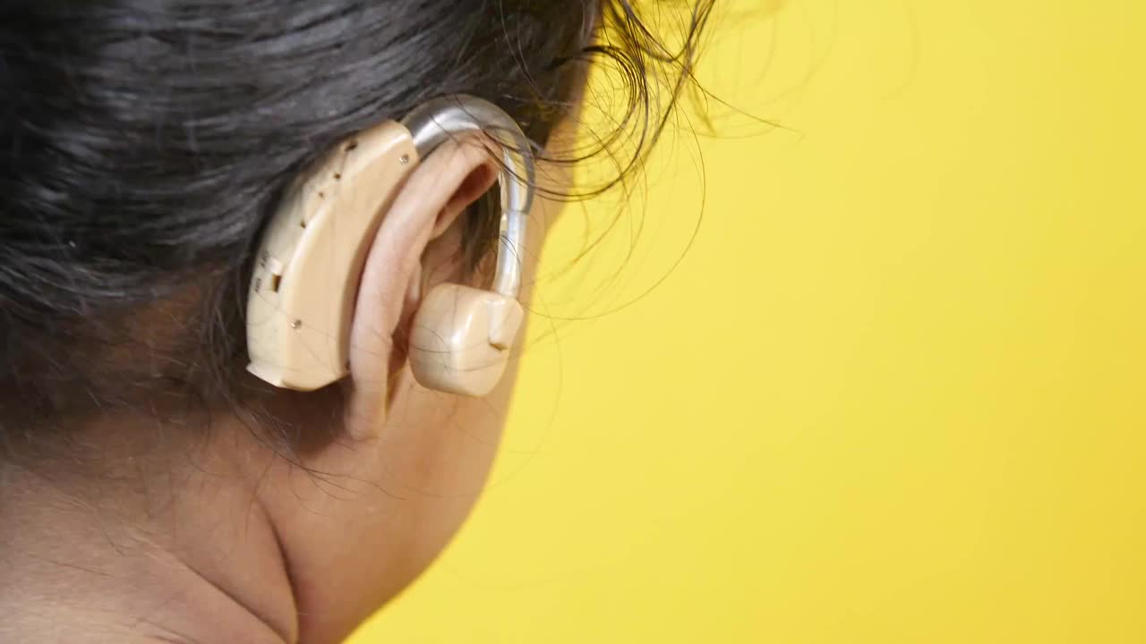 听力有问题的小女孩的助听器概念。视频下载