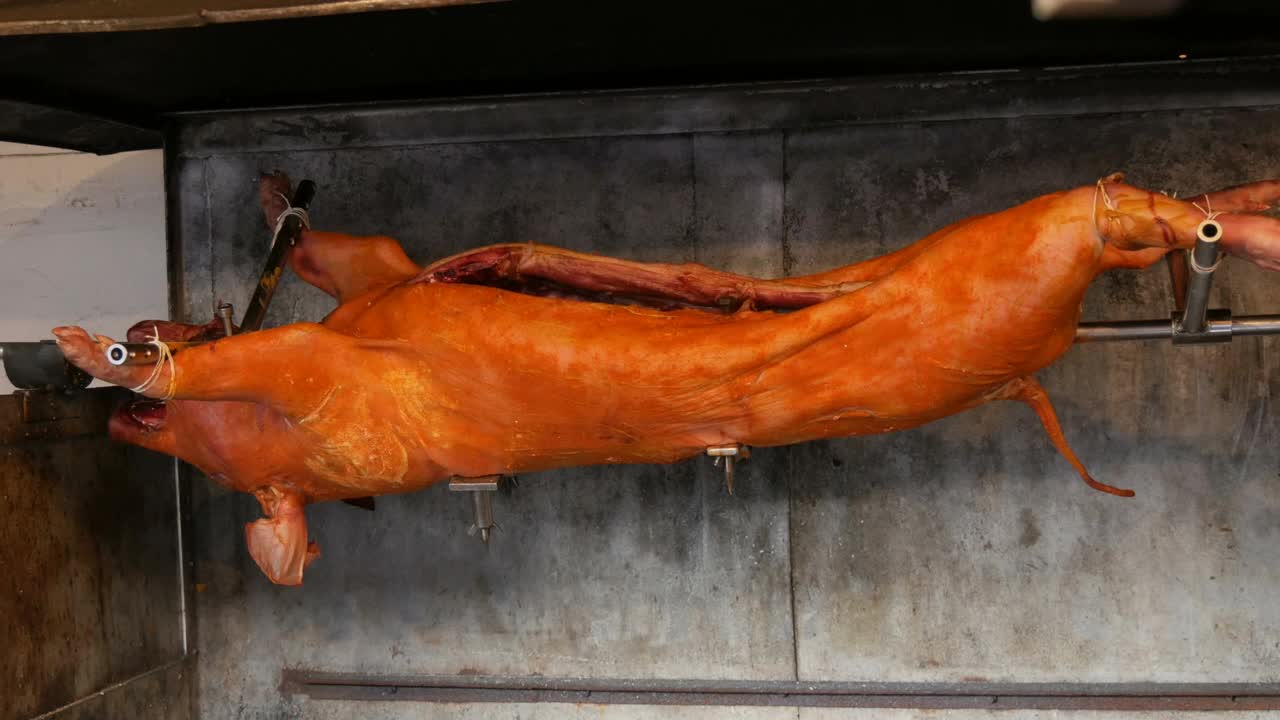 吐在口水上的大猪。慕尼黑中世纪圣诞市场上熏炸的猪尸体。用火和木炭烤制的整只猪肉，是欧洲传统美食的节日美食视频下载