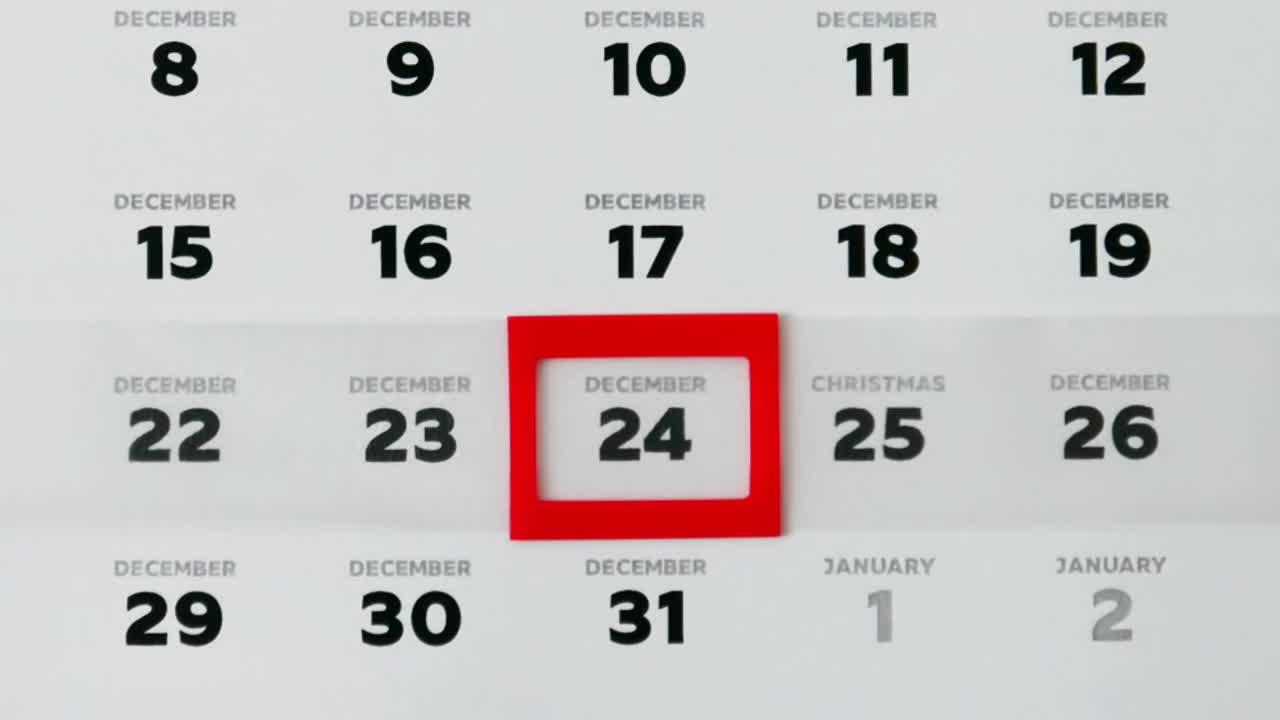 墙上一页漂亮的12月日历和一个男性的手指移动红色光标到圣诞节日期的特写视频素材