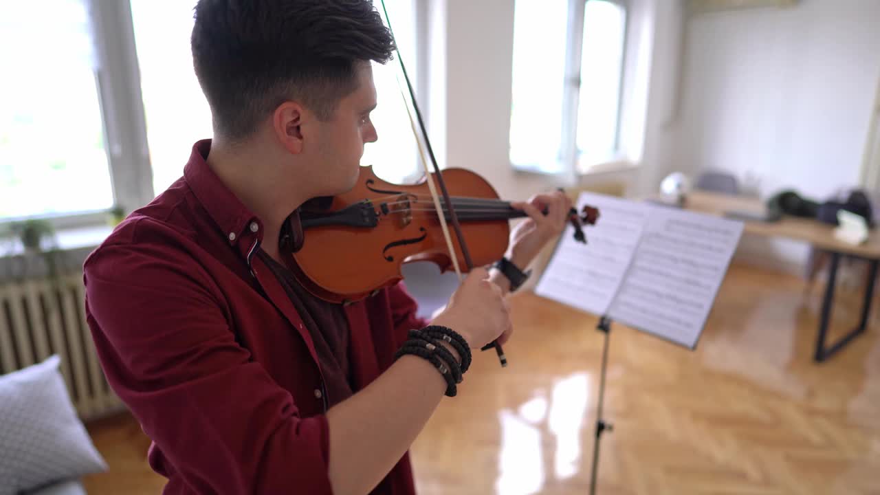 年轻的小提琴家在家里练习演奏视频素材