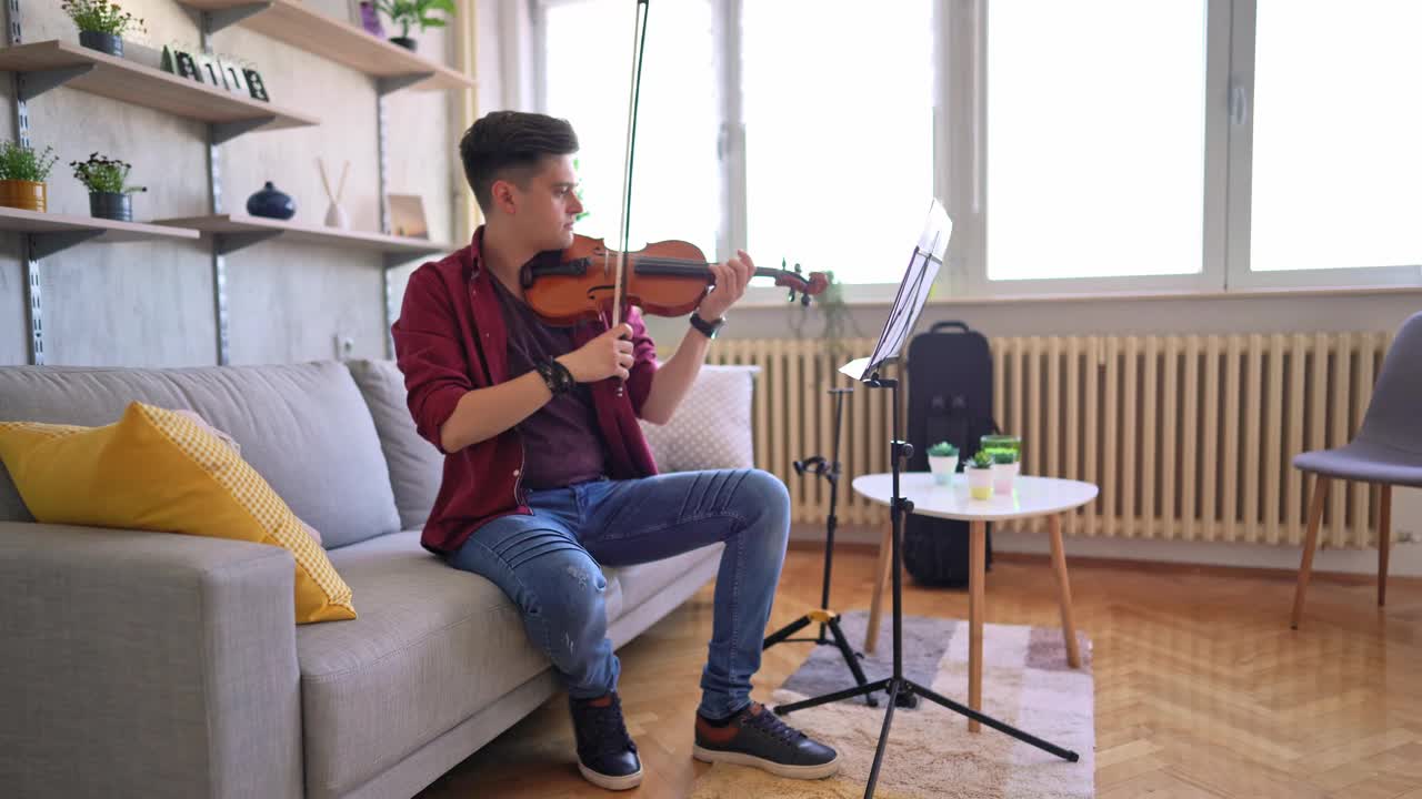 年轻的小提琴家在家里练习演奏视频素材