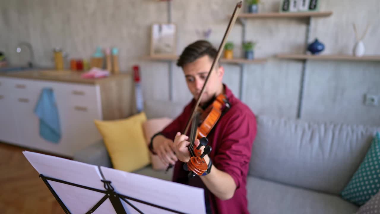 年轻的小提琴家在家里练习演奏视频下载