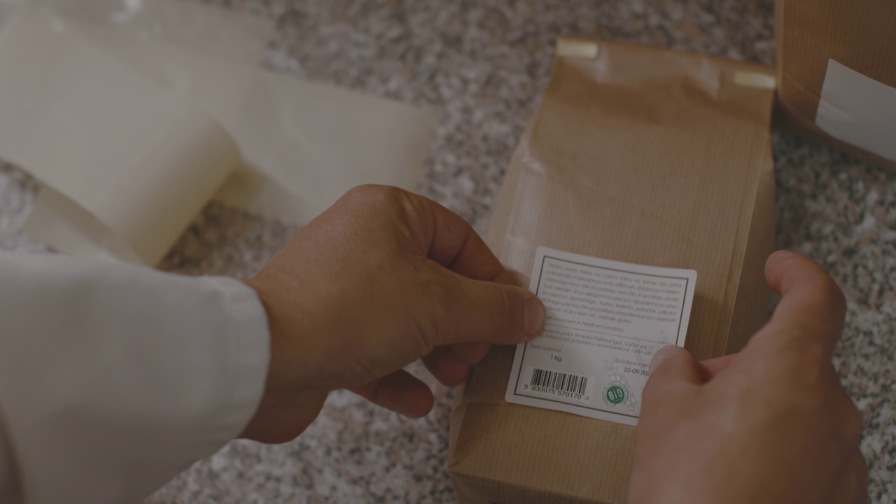 男性的手在面粉包装上粘贴贴纸的特写视频素材
