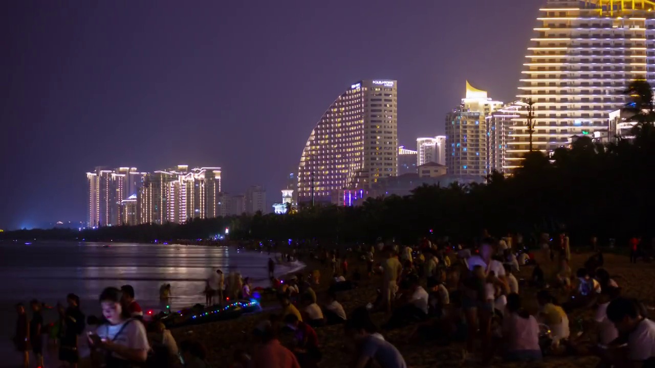 夜晚照明三亚拥挤的海滩海岸线酒店全景4k时间推移海南岛中国视频素材