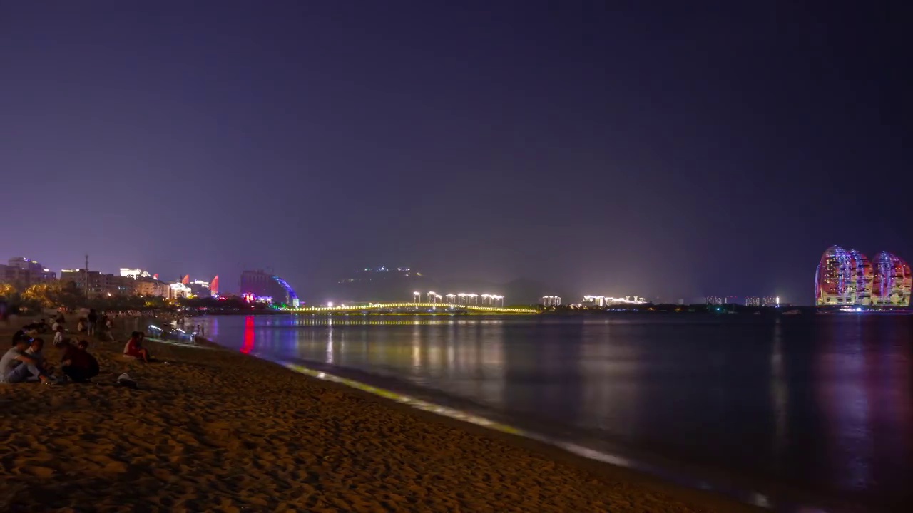 夜光璀璨的三亚拥挤的海滩著名的酒店全景4k时间推移海南岛中国视频素材