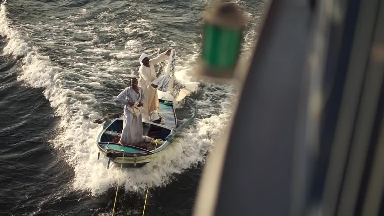 在从卢克索到阿斯旺的尼罗河上，传统的埃及人在船上卖围巾视频下载