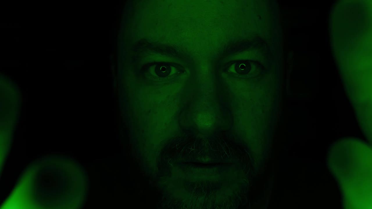 一个男人的画像，在绿色的灯光下，一脸迷惑。视频素材