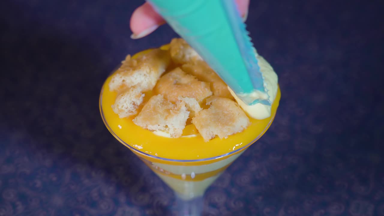 奶油被放在高脚杯里的蛋糕上视频素材