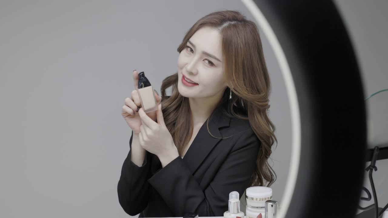 一位穿着黑色西装的美丽韩国女主人在网上卖化妆品视频下载