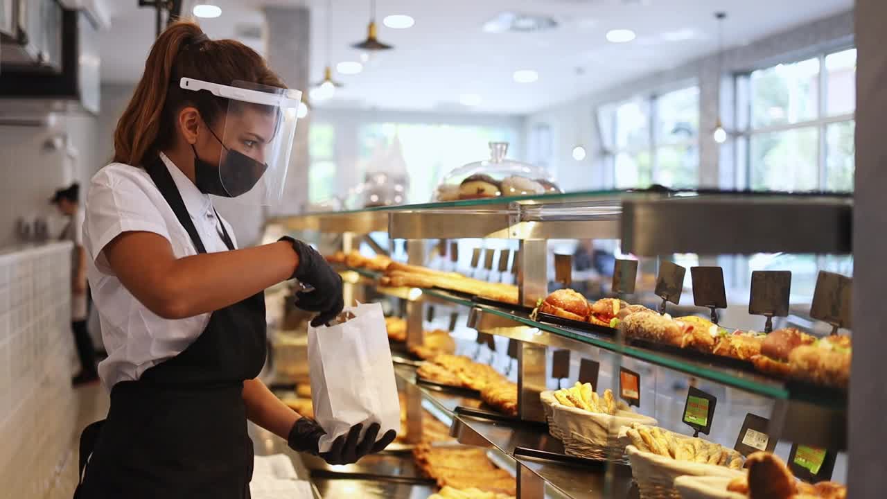 年轻漂亮的女人在面包店工作视频下载