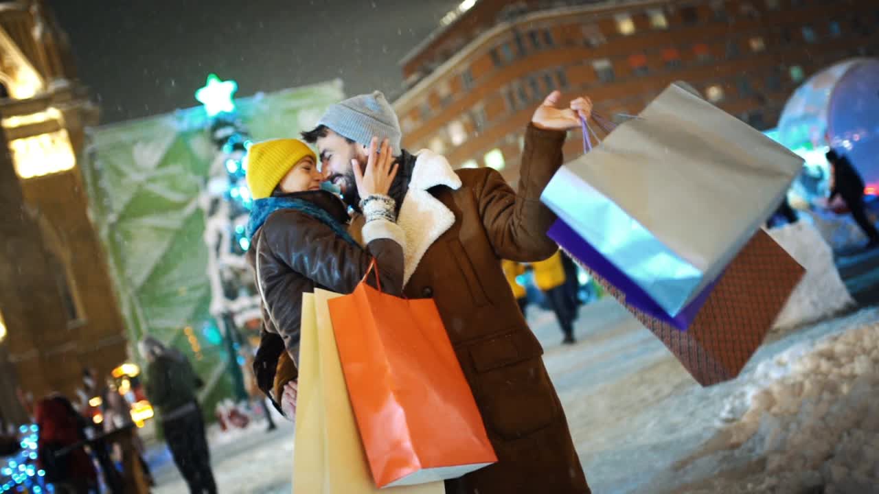 下雪的夜晚，一对夫妇在圣诞市场慢动作。视频素材