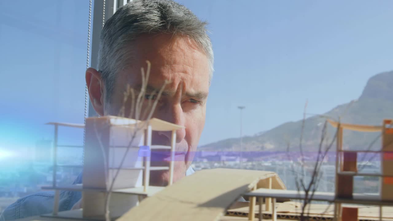 动画的粉红色光束和镜头耀斑男性建筑师在看建筑模型视频素材