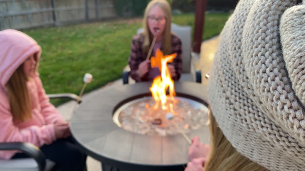 秋天，母亲和女儿们围坐在后院的火坑边做棉花糖夹心饼干边谈笑风生视频下载