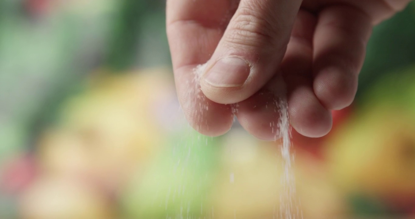 近距离的男性手指盐与精细盐和食物的背景视频下载