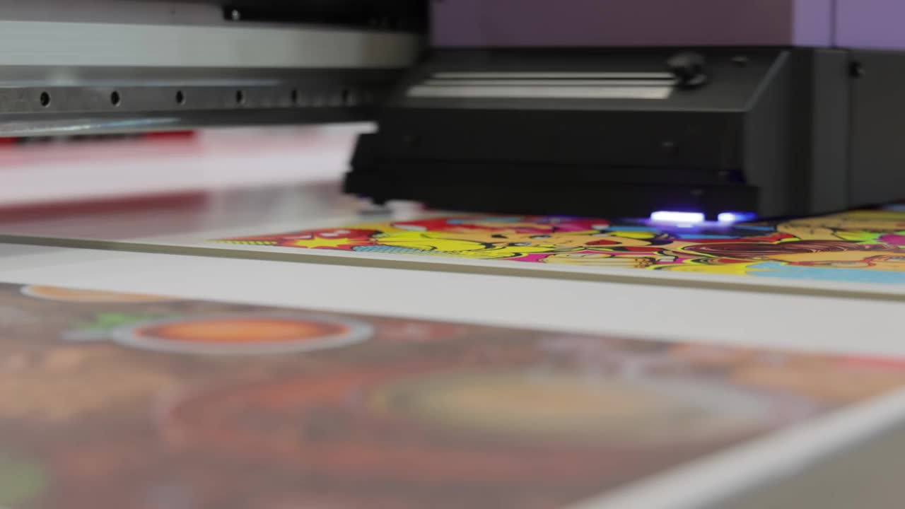 现代数字大格式UV打印机。印刷生产技术。UV钉扎是将一定剂量的低强度紫外线照射到UV固化油墨上的过程视频素材