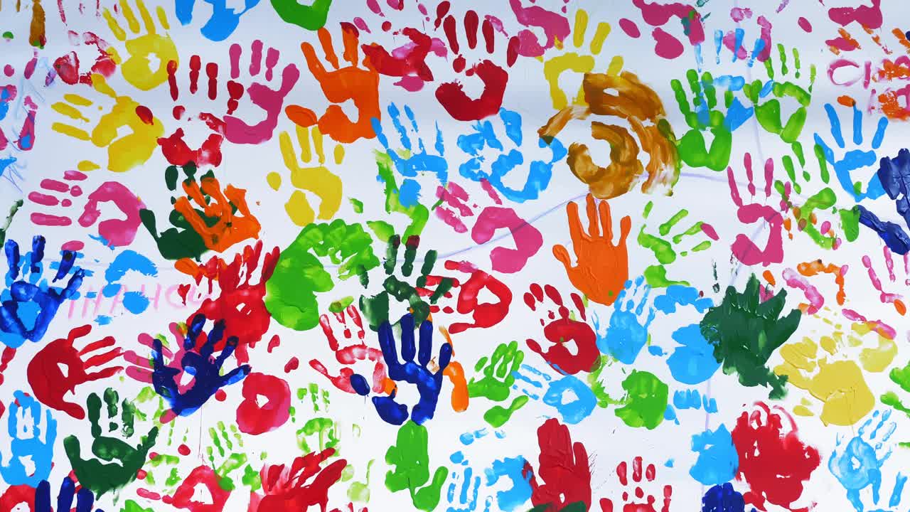 人类的手掌。彩色的手印。特写镜头。艺术。许多彩色的人类手掌印在白色的背景上，白色的墙壁或画布上视频素材