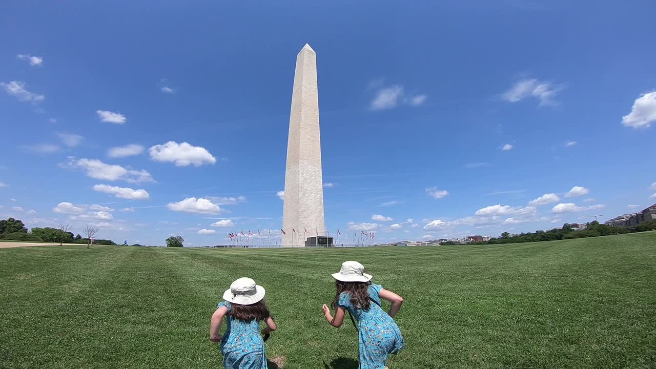 两个年轻的姐妹访问华盛顿特区，跑向华盛顿纪念碑，高兴和兴奋。视频下载