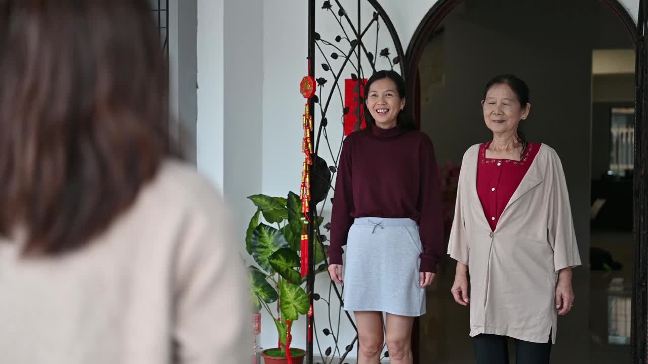 在中国新年期间，年轻漂亮的亚洲女性拜访她的祖父母家，给父母送礼物和食物视频素材