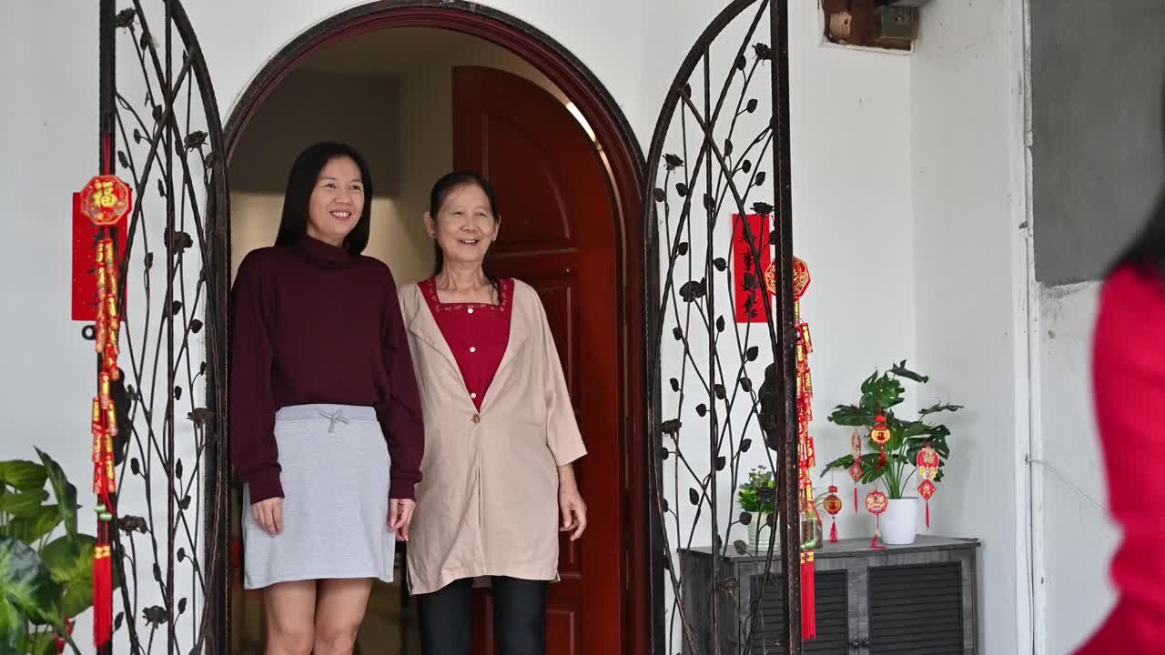 美丽的年轻亚洲妇女访问她的祖父母家给父母的礼物和食物在中国新年视频素材