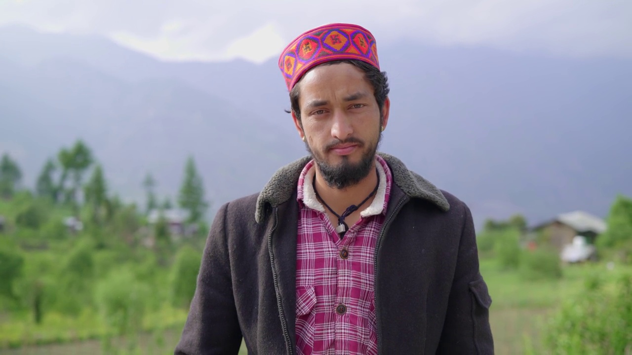 一名年轻的印度喜马偕利族男性(帕哈里族男性)，头戴传统或民族帽子，后面有山脉视频下载