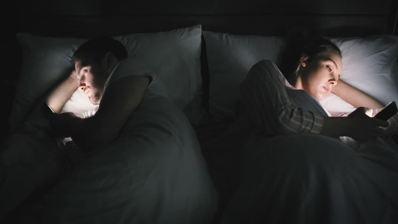 一对夫妇在家里的床上用手机无视对方的4k视频视频下载