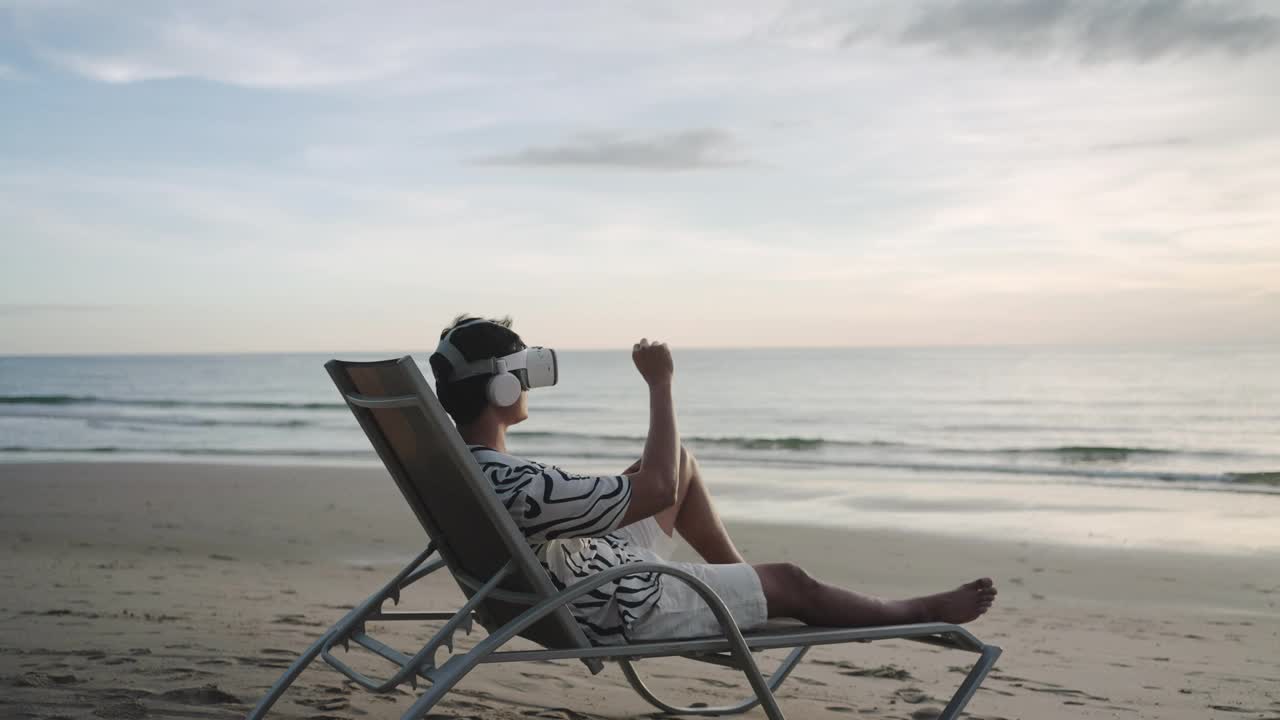 年轻的亚洲男子使用虚拟现实眼镜在美丽的大海和天空背景的热带海滩商务会议视频素材