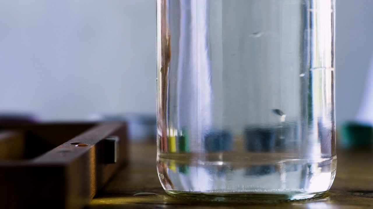 黄色的特写镜头溶解在一杯水里。4 k视频下载