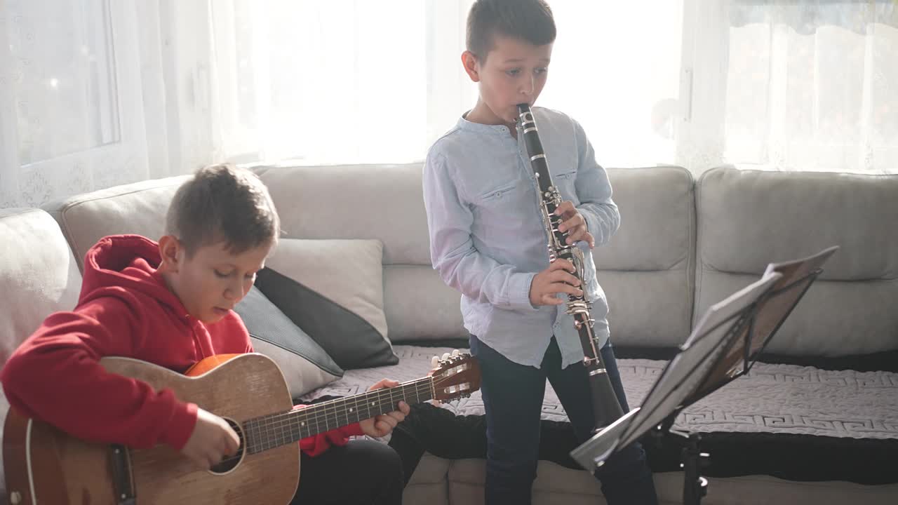 儿童兄弟与吉他和单簧管演奏音乐根据表视频下载