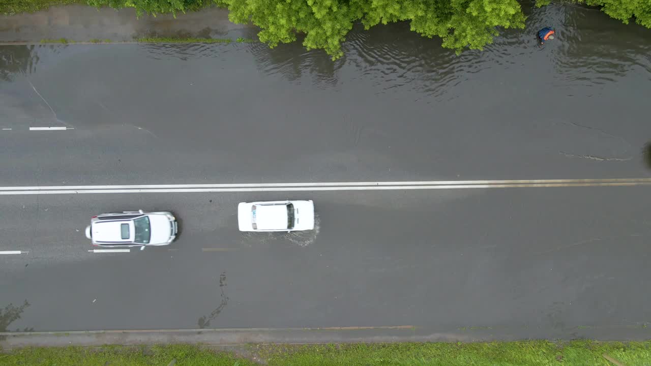 鸟瞰图的城市交通与汽车驾驶在被淹的街道后大雨。道路排水系统的问题视频素材