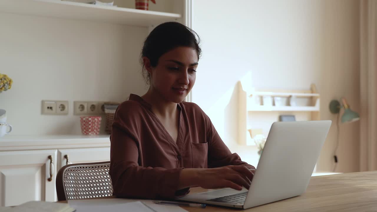 沉思的印度千禧一代女性在笔记本电脑上上网视频素材