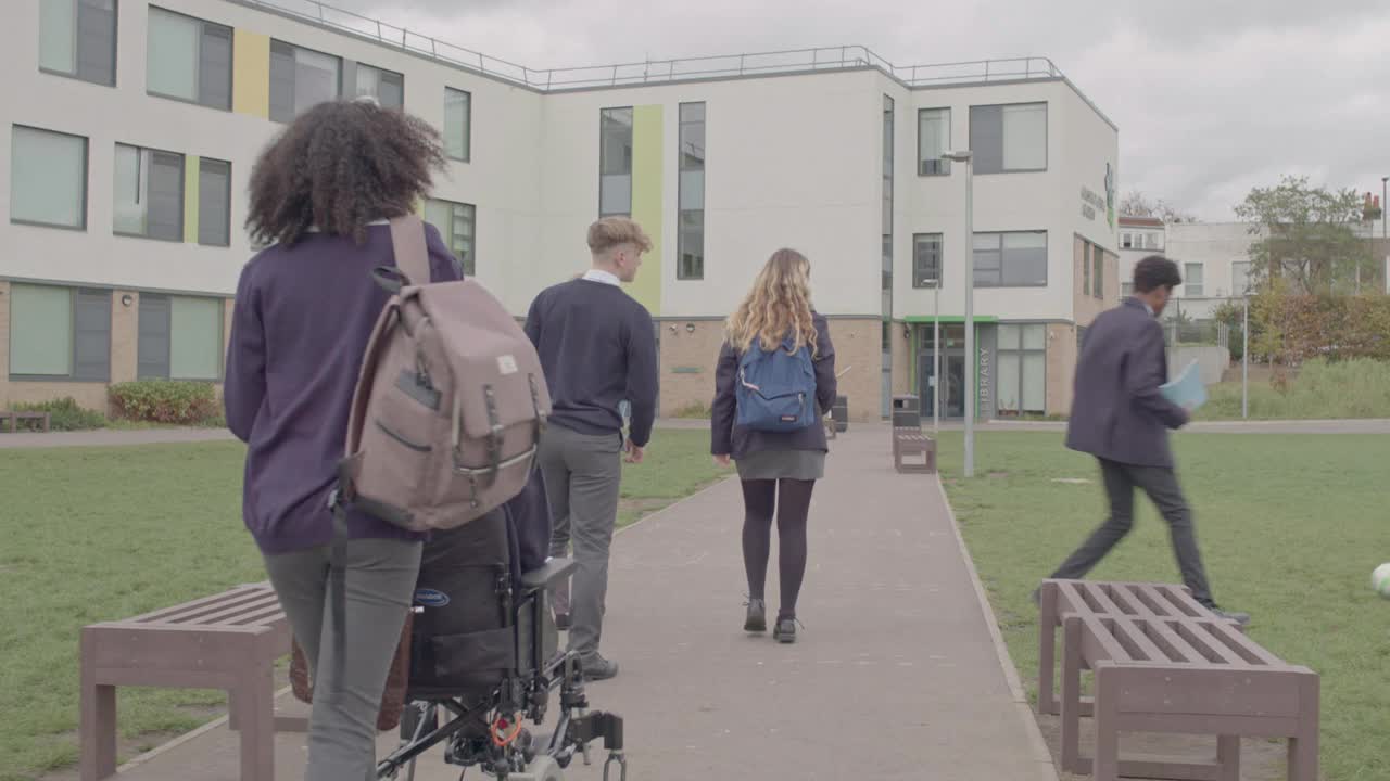 不同的英国青少年穿过中学校园视频素材