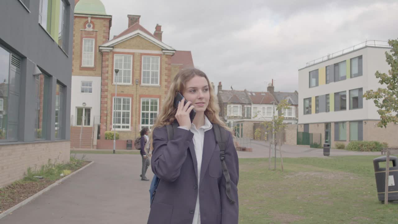 英国中学生在校园里使用手机视频下载