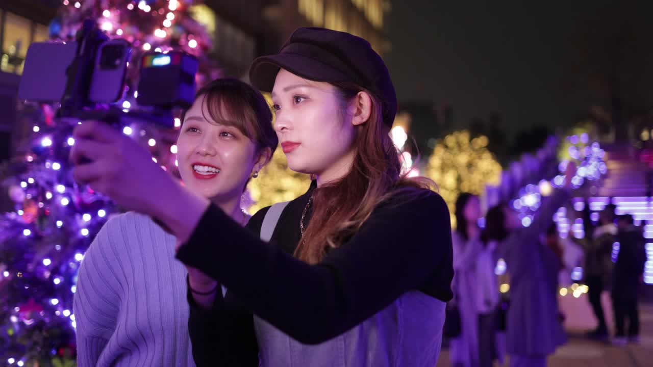 年轻的女性朋友在圣诞节的灯光下自拍电影视频下载