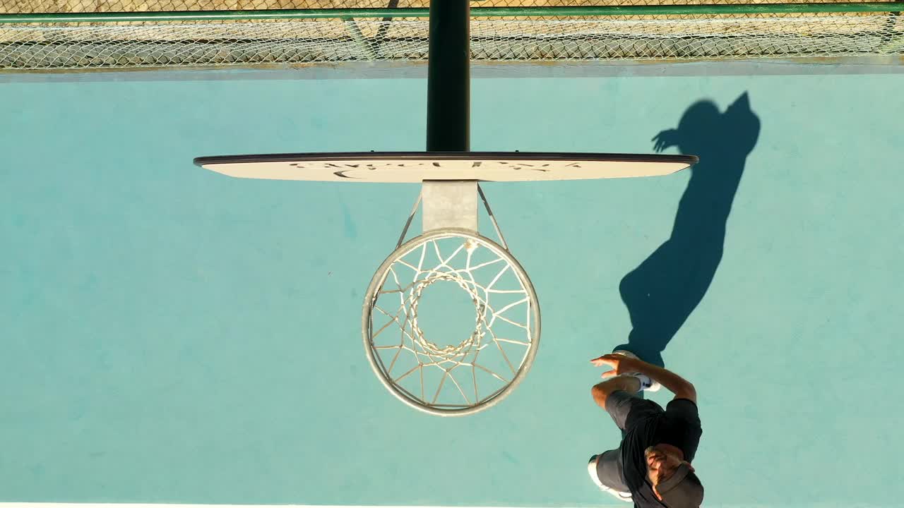 一个男人在葡萄牙里斯本的篮球场上投篮的特写镜头，摄于白天视频下载