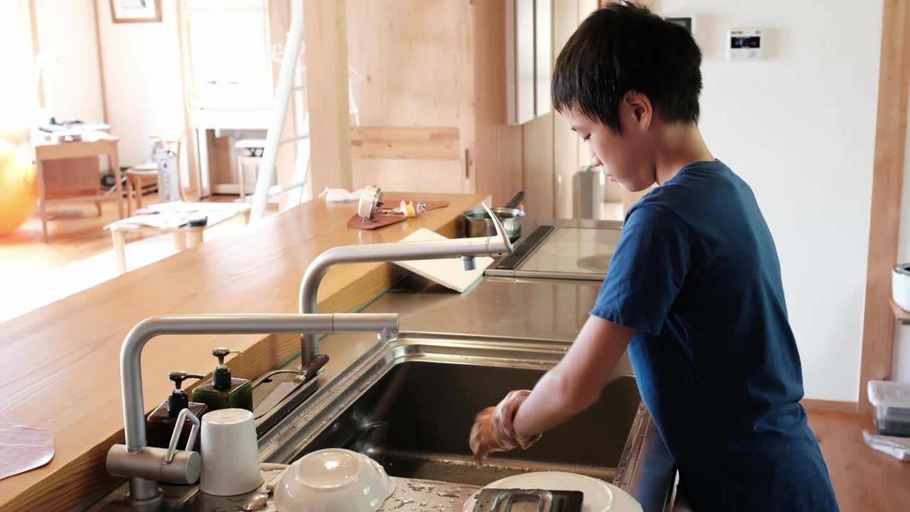 男孩在厨房里洗手视频素材