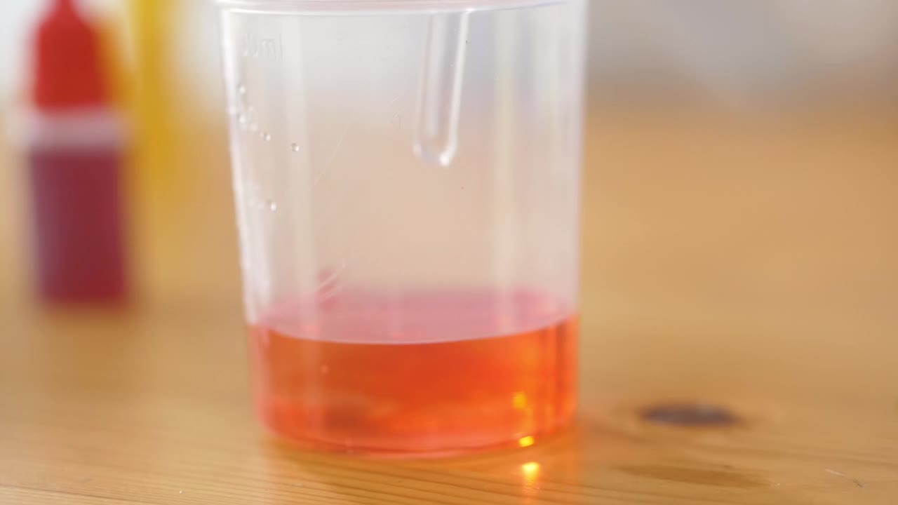 在烧杯中搅拌橘子，科学实验。视频下载