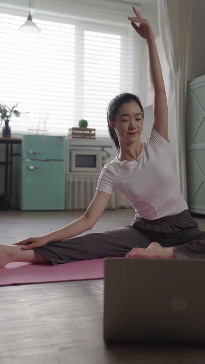 这位年轻女子在家做瑜伽视频下载