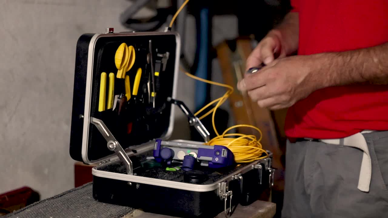现场工人调整和准备他的工具，以便他可以修复光纤电缆视频素材