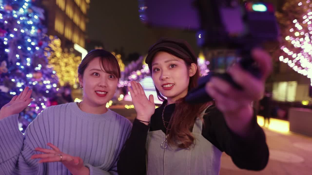 年轻的女性朋友在圣诞节的灯光下自拍视频视频下载