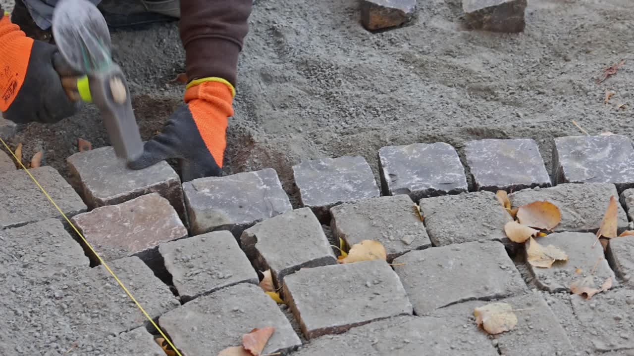 手套师傅由专业摊铺工分层铺石路面视频素材