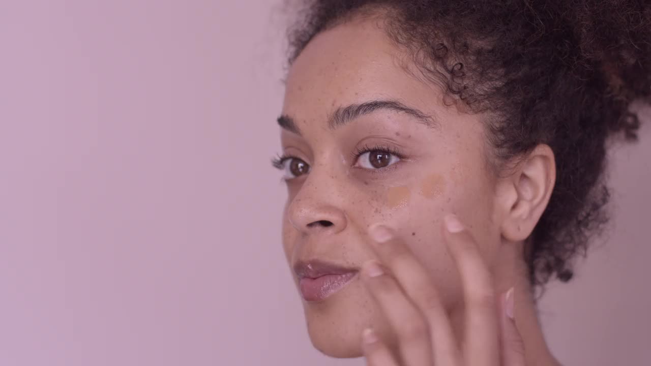 年轻成年女性涂抹粉底的特写视频下载
