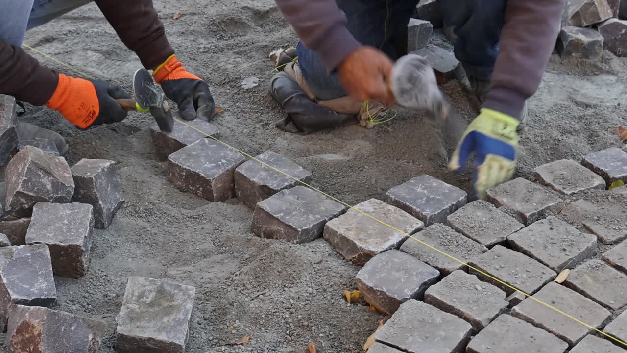 铺路工人用铁锤铺路用花岗石、鹅卵石铺路视频素材